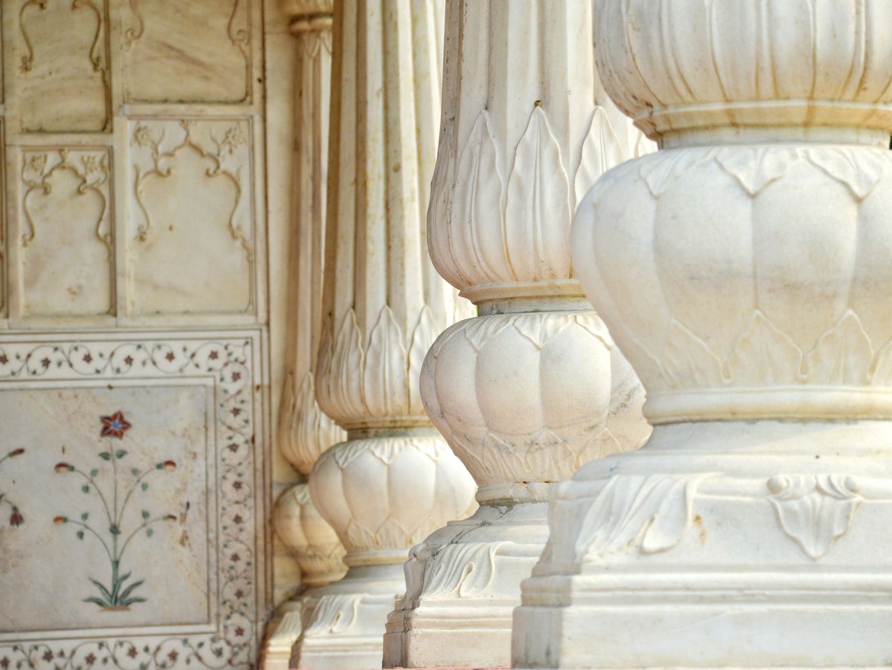 hero-img-01 Detailed view of ornate marble columns showcasing intricate carvings in historical architecture.
