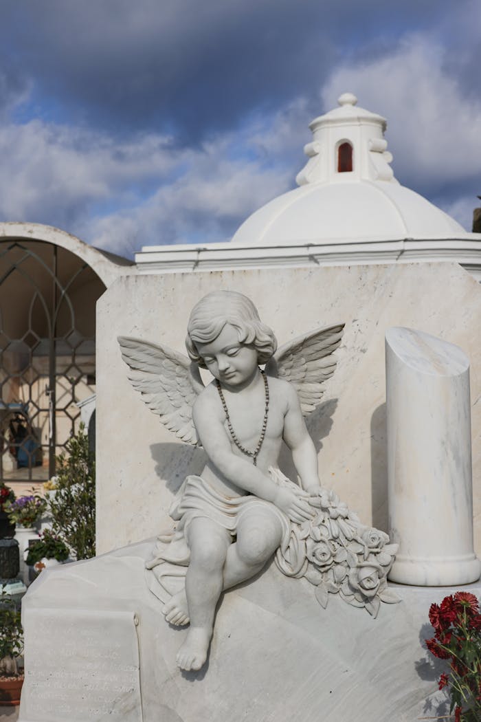 gallery-5 Beautiful angel statue in a peaceful cemetery setting under a vibrant sky.