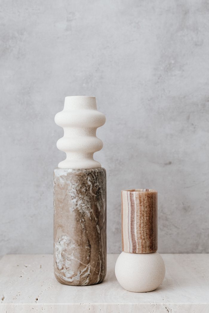 services-01 Elegant marble vases with a geometric design on a textured gray surface.